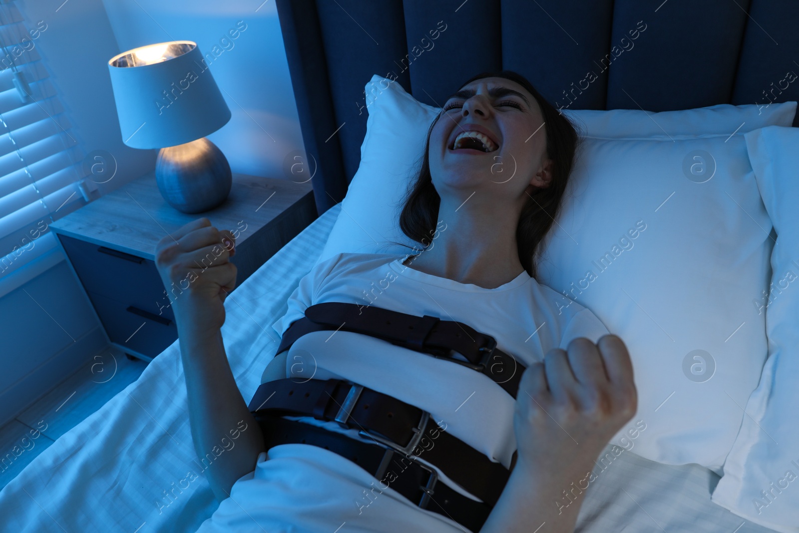 Photo of Woman in sleepwalking condition screaming on bed