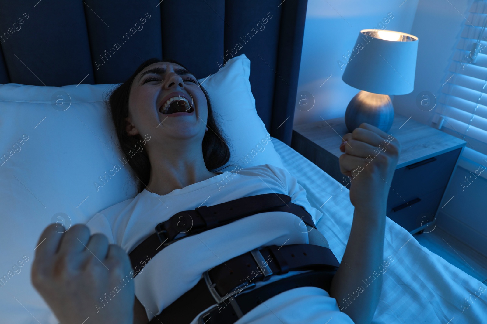 Photo of Woman in sleepwalking condition screaming on bed