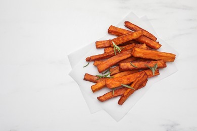 Photo of Delicious sweet potato fries with rosemary on white marble table, top view. Space for text