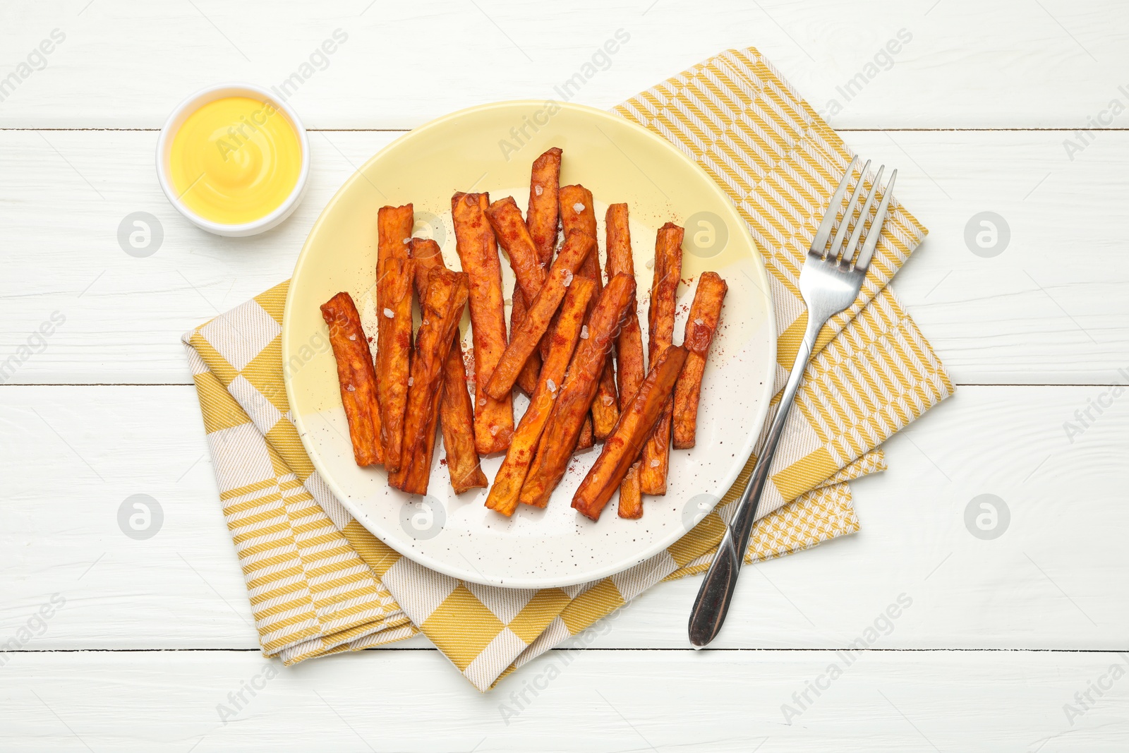 Photo of Delicious sweet potato fries and sauce on white wooden table, top view