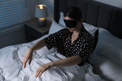 Photo of Young woman suffering from sleepwalking on bed at home