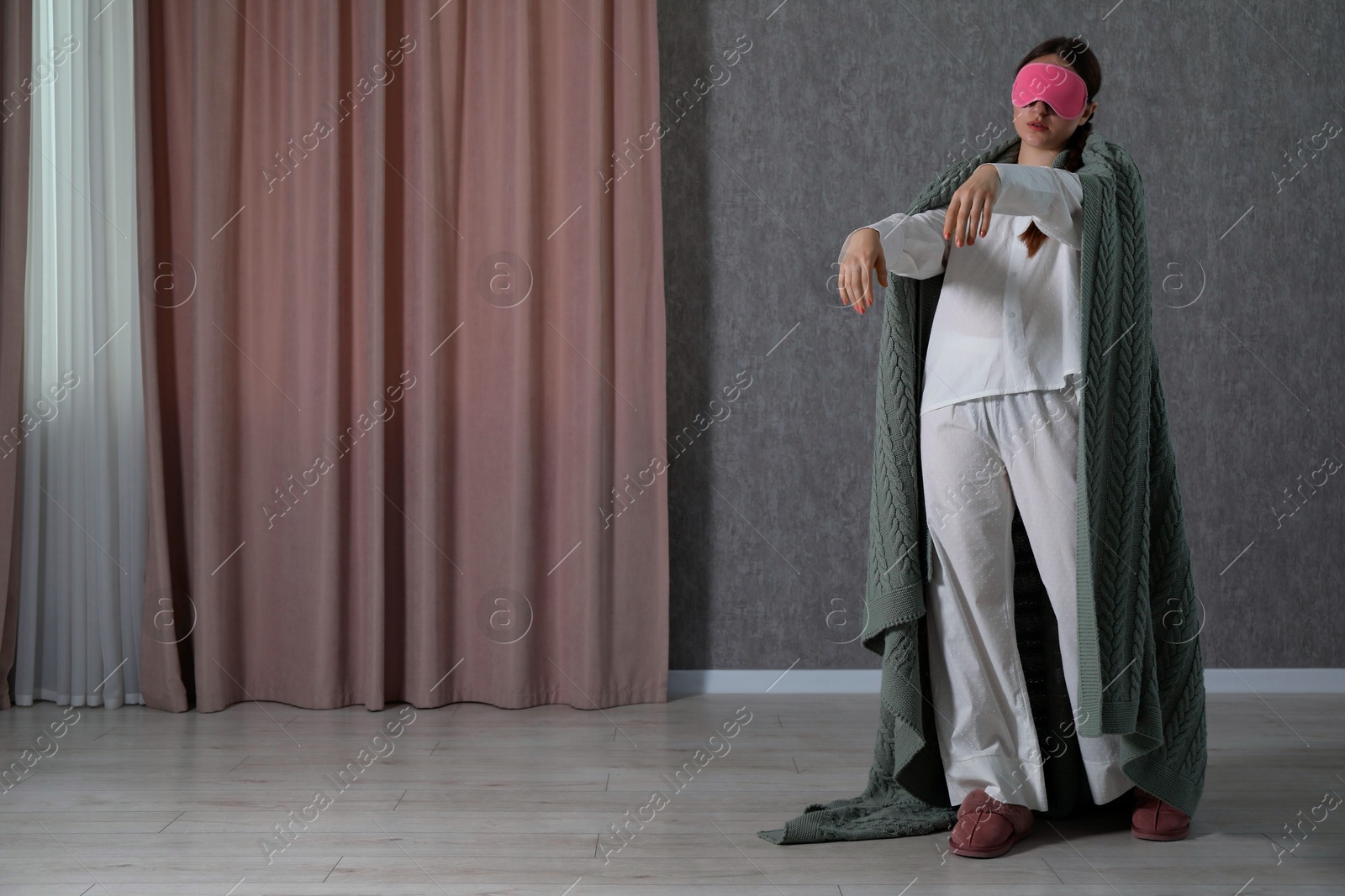 Photo of Young woman suffering from sleepwalking at home, space for text