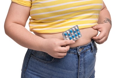 Photo of Plus size woman with blister of weight loss supplements on white background, closeup