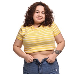 Photo of Weight loss. Happy plus size woman in big pants on white background