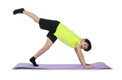 Photo of Boy exercising on fitness mat against white background. Sport activity