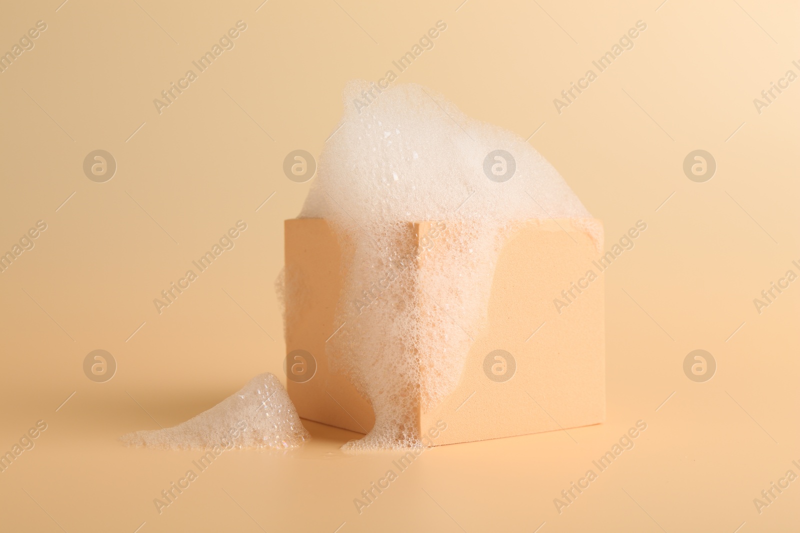 Photo of Cube podium with foam on beige background