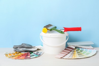 Photo of Different painter's tools on white wooden table. Decorating and design