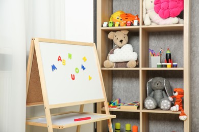 Beautiful kid's room interior with toys, whiteboard and stylish furniture