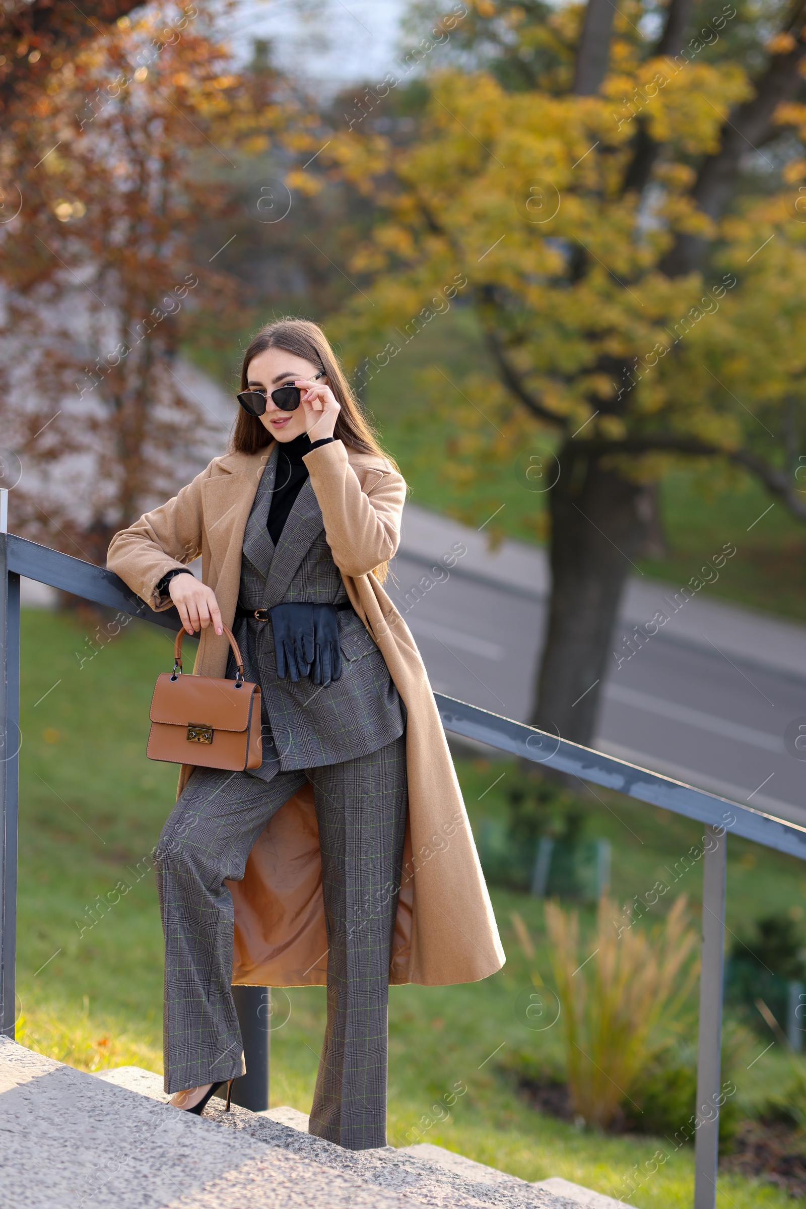 Photo of Businesswoman in stylish suit on stairs outdoors. Space for text