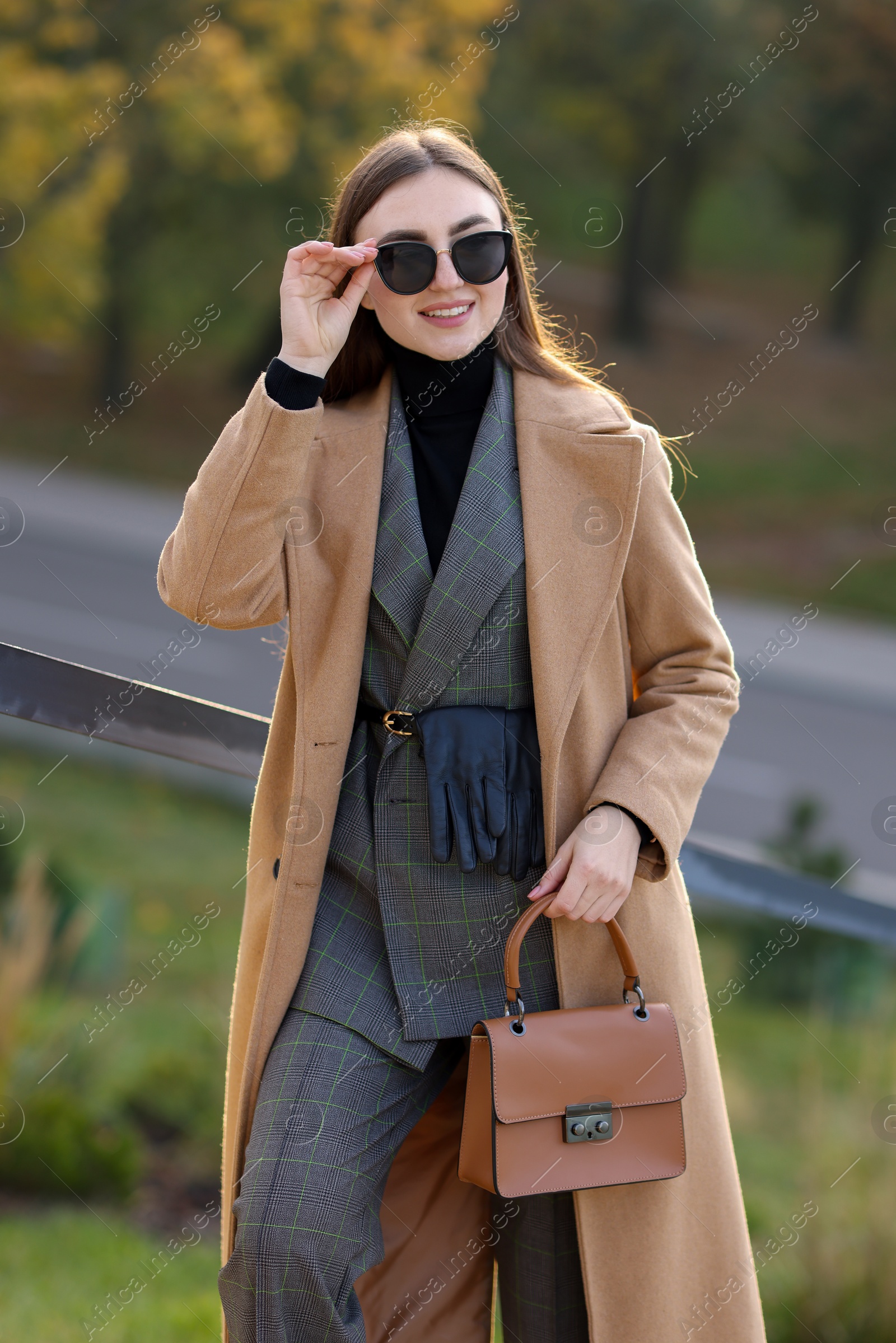 Photo of Portrait of smiling businesswoman in stylish suit outdoors