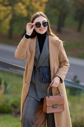 Photo of Portrait of smiling businesswoman in stylish suit outdoors