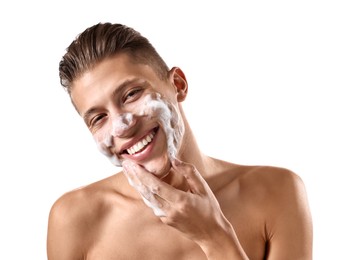 Photo of Smiling man washing his face with cleansing foam on white background