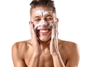 Photo of Smiling man washing his face with cleansing foam on white background