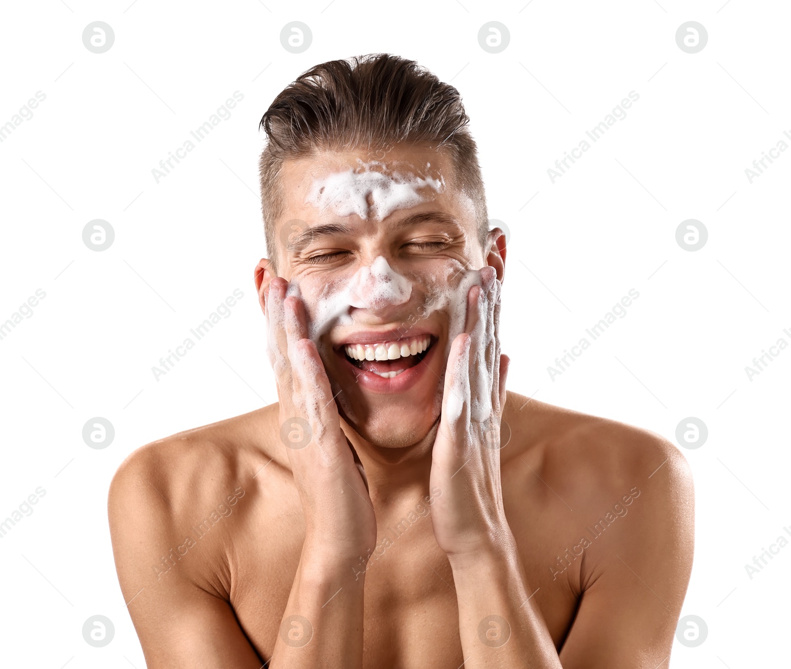 Photo of Smiling man washing his face with cleansing foam on white background