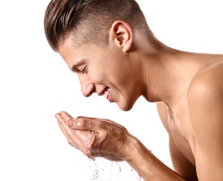 Smiling man washing his face on white background