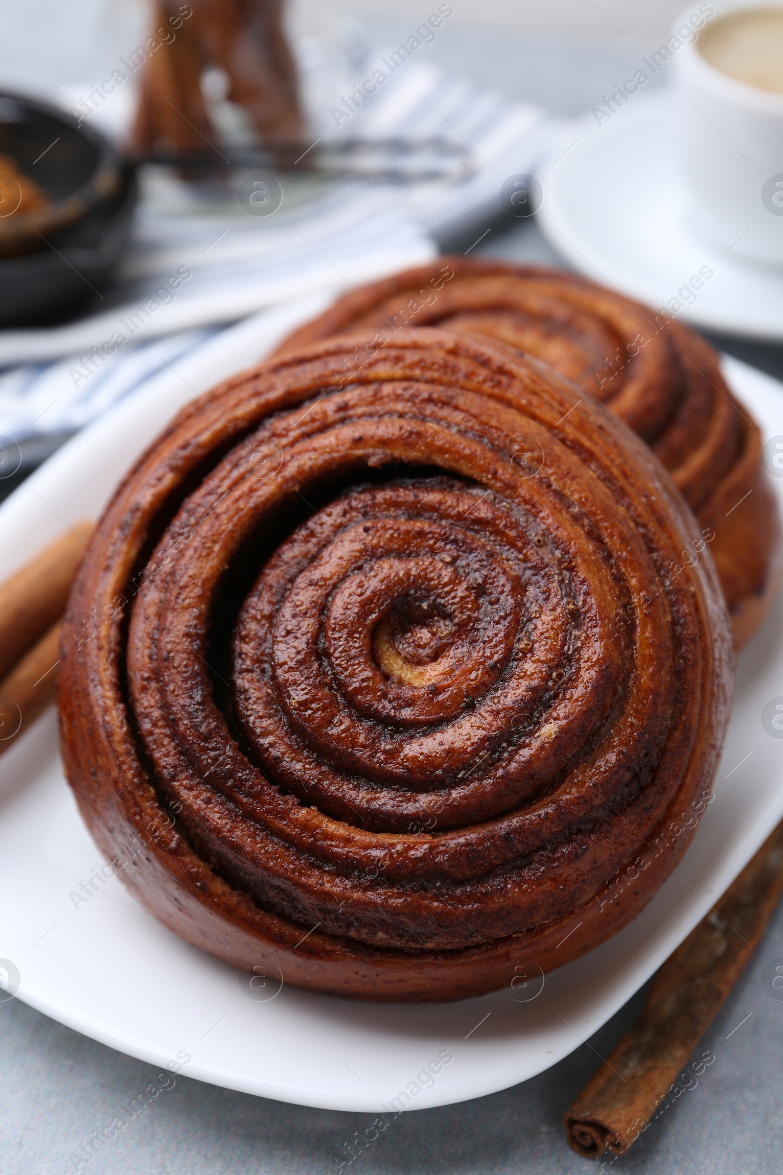 Photo of Delicious cinnamon rolls on grey table, closeup