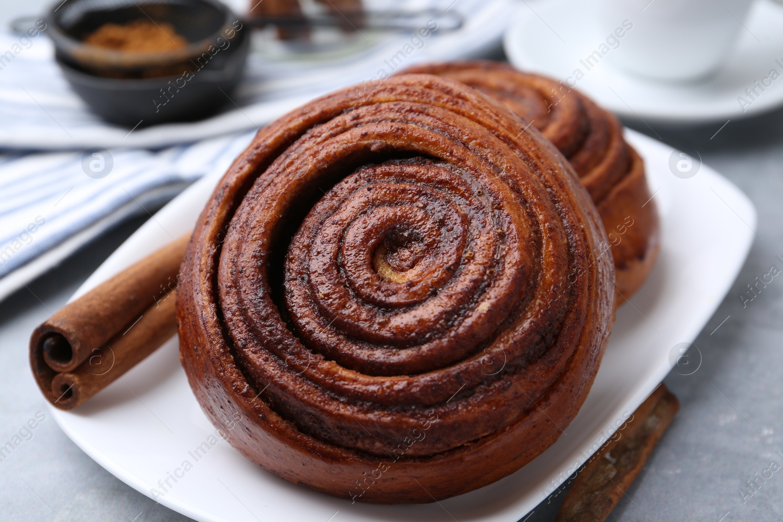 Photo of Delicious cinnamon rolls on grey table, closeup