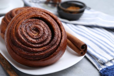 Photo of Delicious cinnamon rolls on grey table, closeup