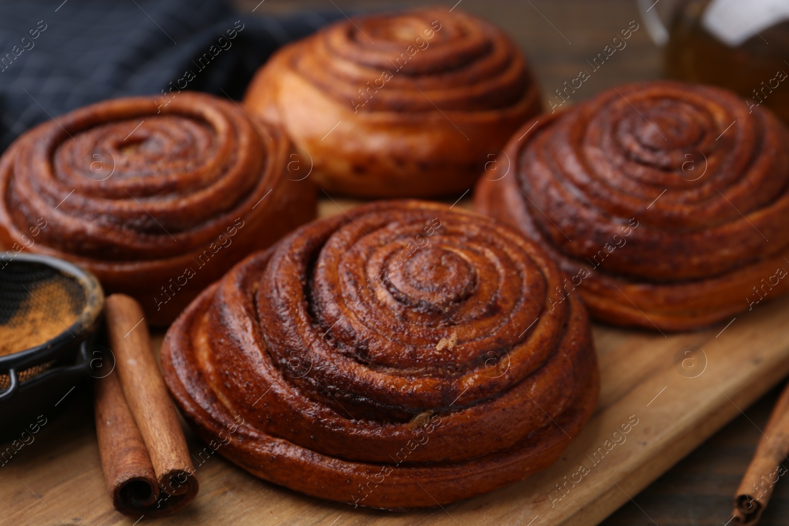 Photo of Delicious cinnamon rolls on wooden table, closeup