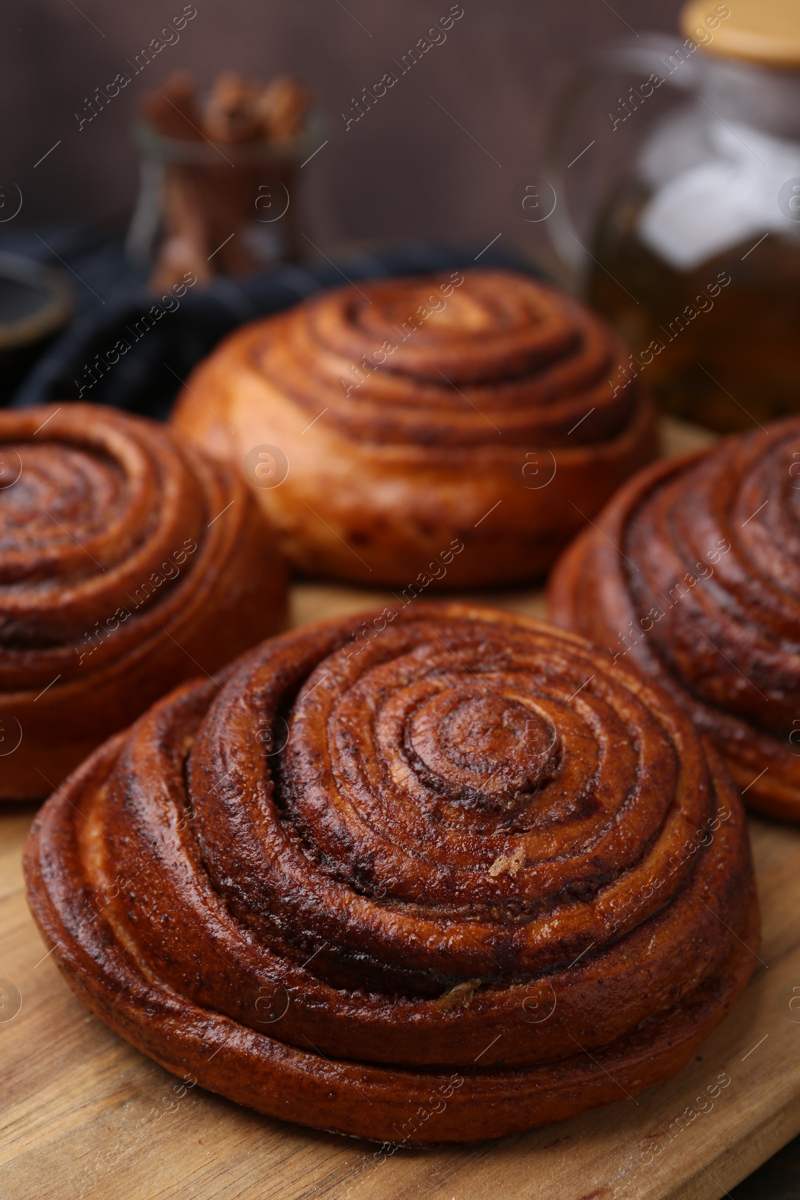 Photo of Delicious cinnamon rolls on wooden board, closeup