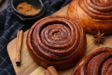 Photo of Delicious cinnamon rolls and spices on table, closeup