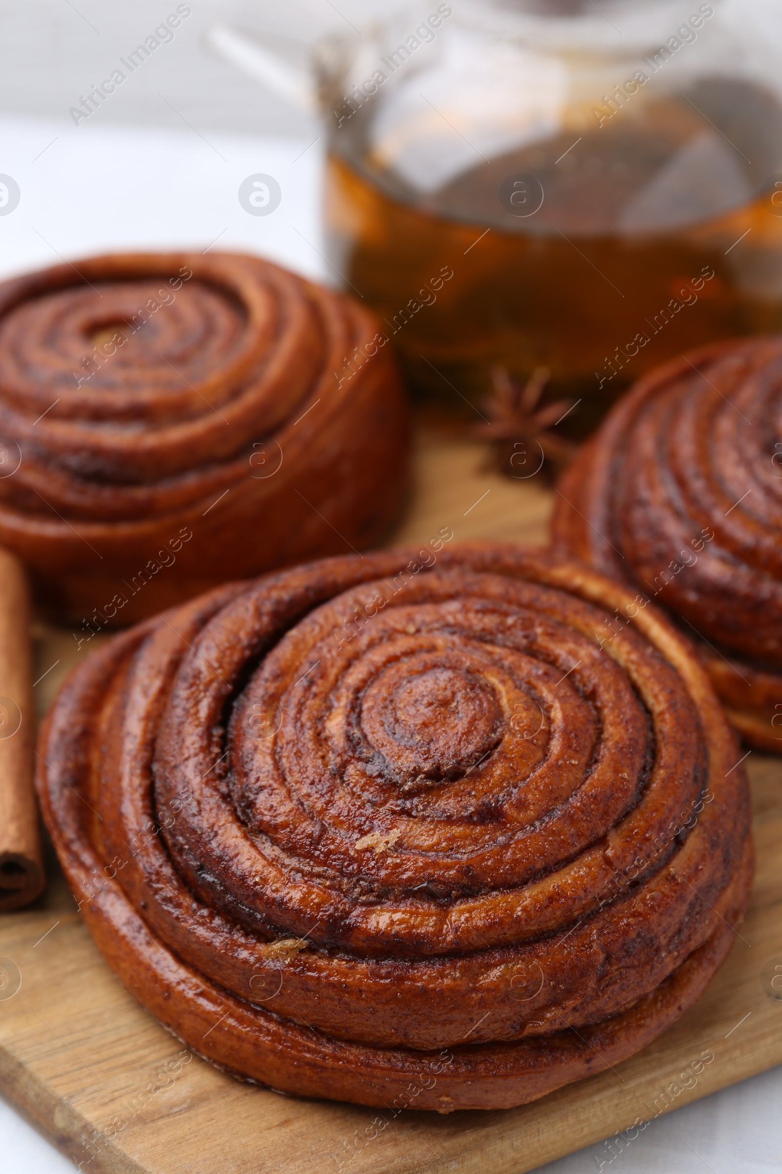 Photo of Delicious cinnamon rolls on white table, closeup