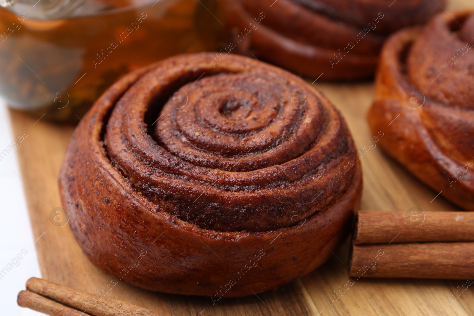 Photo of Delicious cinnamon rolls and sticks on white table, closeup