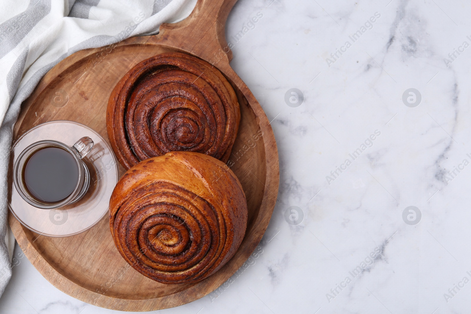 Photo of Delicious cinnamon rolls and coffee on white marble table, top view. Space for text