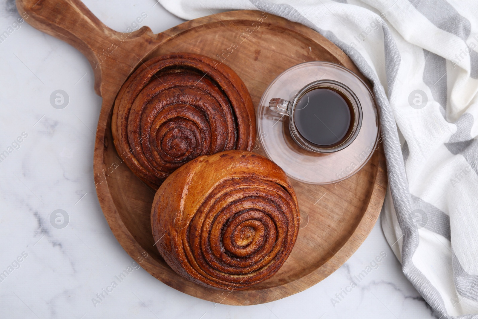 Photo of Delicious cinnamon rolls and coffee on white marble table, top view