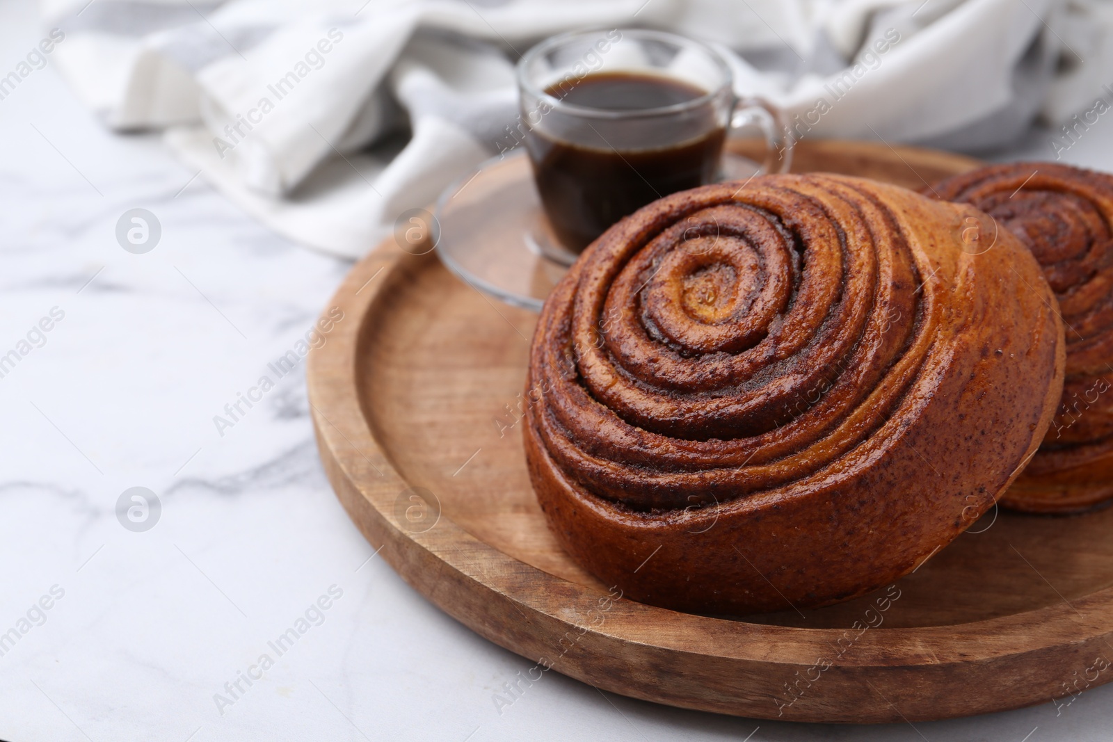 Photo of Delicious cinnamon rolls on white marble table, closeup. Space for text