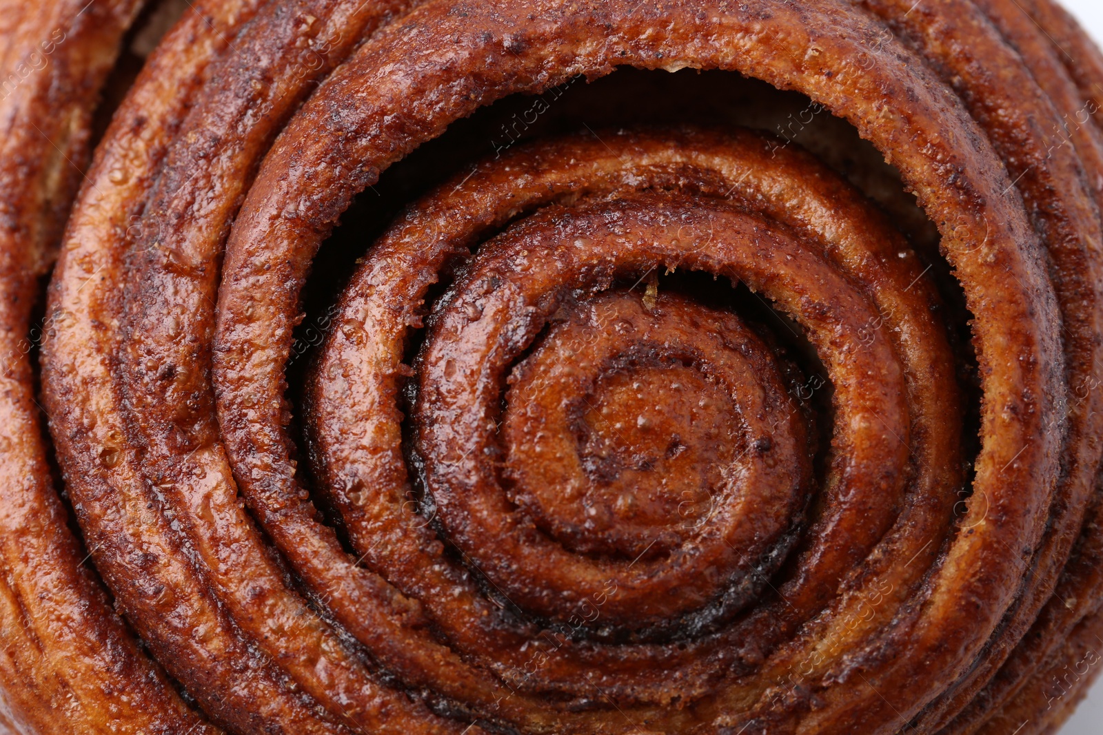 Photo of Tasty cinnamon roll bun as background, closeup