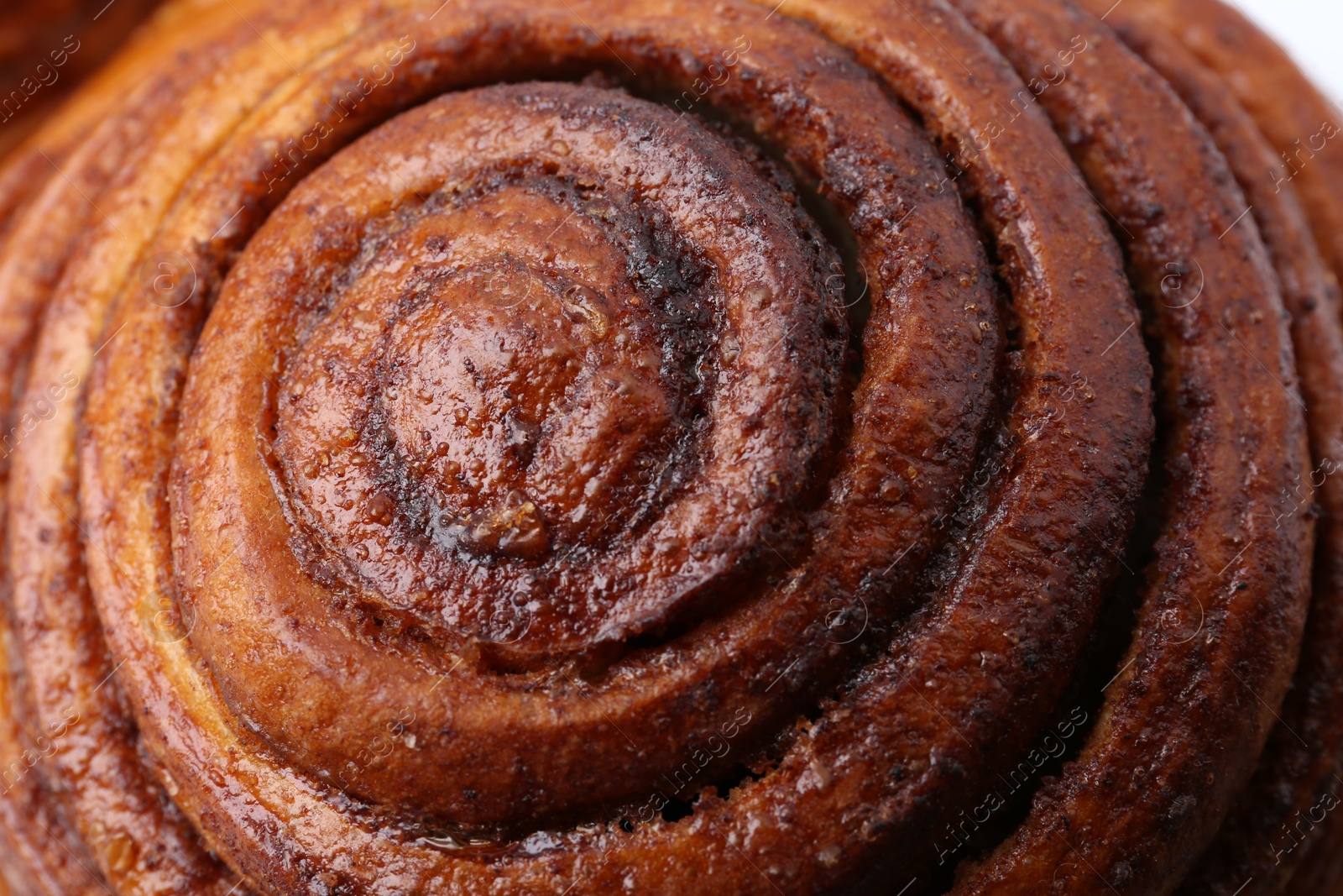 Photo of Tasty cinnamon roll bun as background, closeup