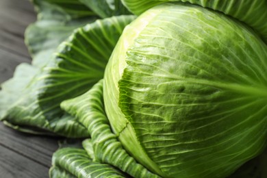 Photo of One ripe head of cabbage on black wooden table, closeup