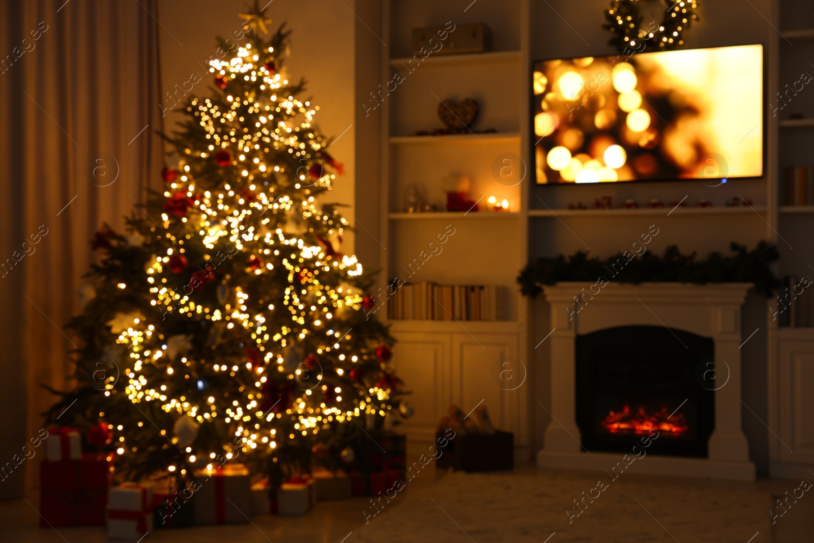 Photo of Blurred view of beautifully decorated Christmas tree near fireplace in room. Festive interior design