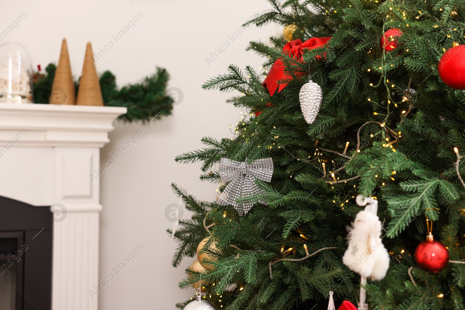 Photo of Christmas tree decorated with beautiful ornaments and festive lights indoors, closeup