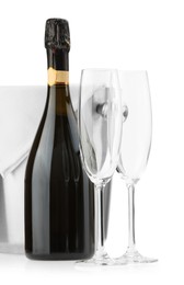 Photo of Bottle of champagne, empty glasses and ice bucket isolated on white