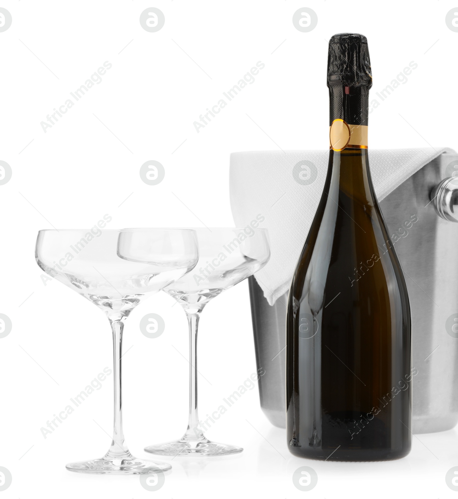 Photo of Bottle of champagne, empty glasses and ice bucket isolated on white