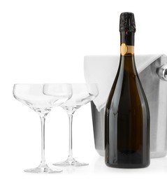 Photo of Bottle of champagne, empty glasses and ice bucket isolated on white