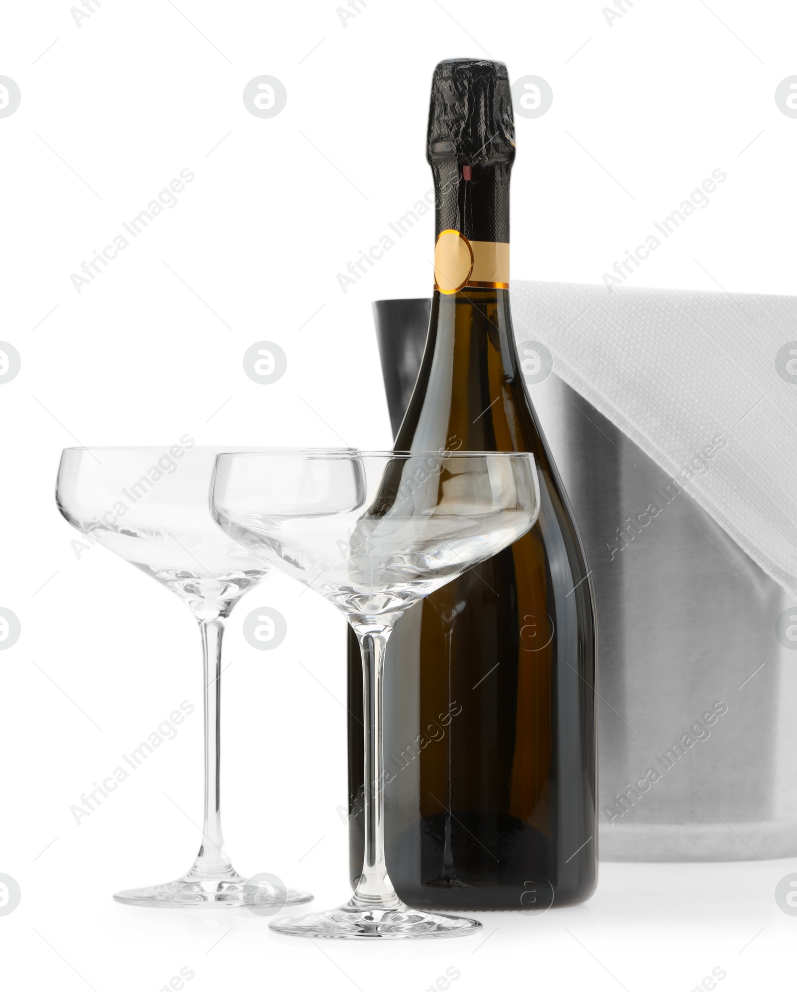 Photo of Bottle of champagne, empty glasses and ice bucket isolated on white