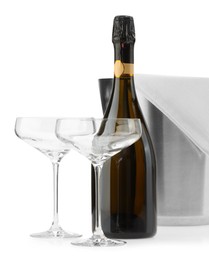 Photo of Bottle of champagne, empty glasses and ice bucket isolated on white