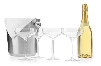 Photo of Bottle of champagne, empty glasses and ice bucket isolated on white