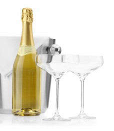 Photo of Bottle of champagne, empty glasses and ice bucket isolated on white