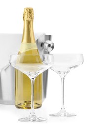 Photo of Bottle of champagne, empty glasses and ice bucket isolated on white