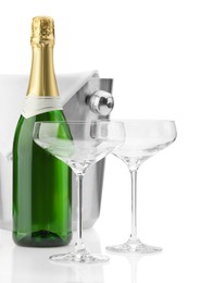 Photo of Bottle of champagne, empty glasses and ice bucket isolated on white