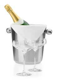 Photo of Bottle of champagne in ice bucket and empty glasses isolated on white