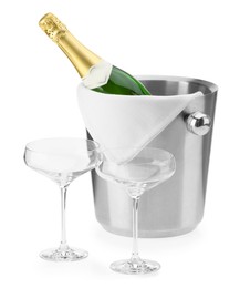 Photo of Bottle of champagne in ice bucket and empty glasses isolated on white