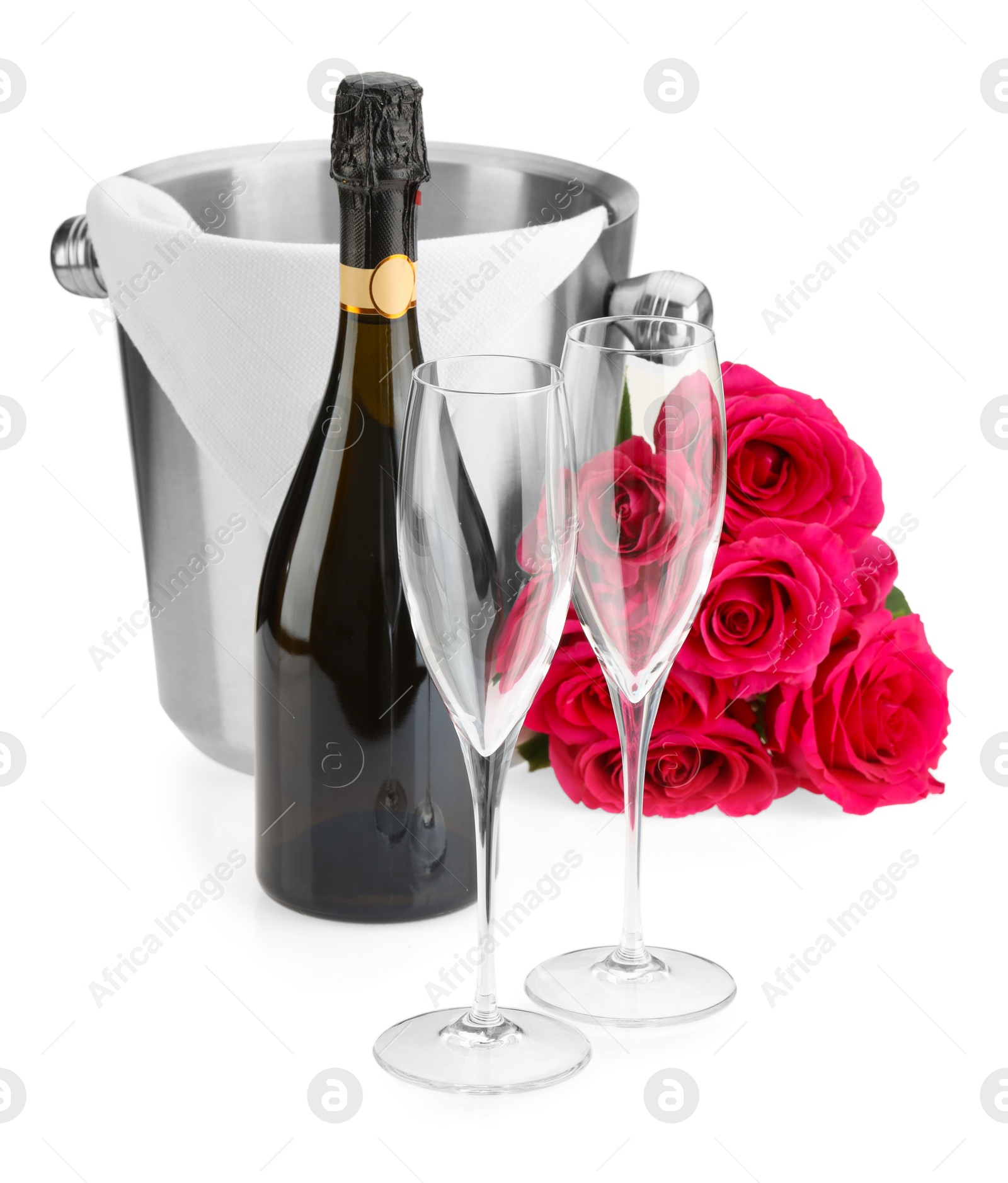 Photo of Bottle of champagne, empty glasses, beautiful roses and ice bucket isolated on white