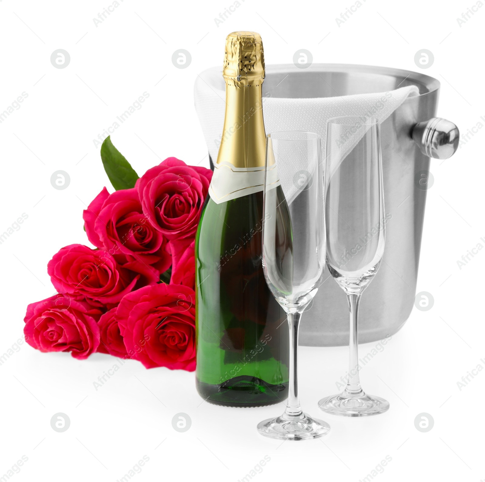 Photo of Bottle of champagne, empty glasses, beautiful roses and ice bucket isolated on white