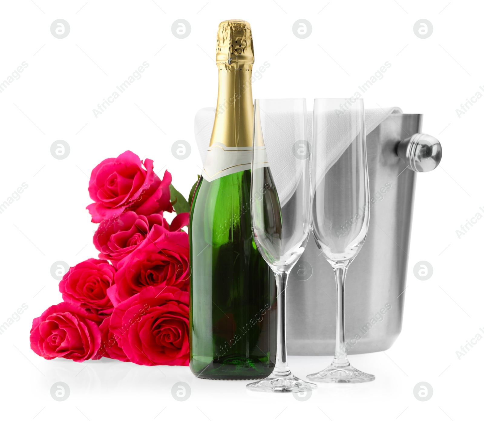 Photo of Bottle of champagne, empty glasses, beautiful roses and ice bucket isolated on white