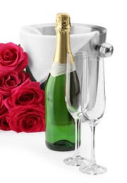 Photo of Bottle of champagne, empty glasses, beautiful roses and ice bucket isolated on white